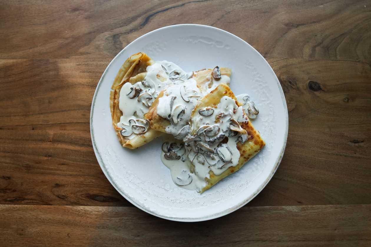 Crepes with cheese, ham and mushroom sauce