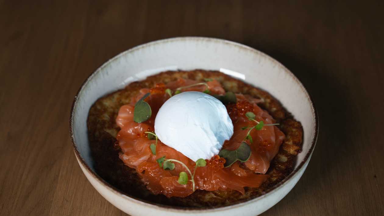 Potato pancake with salmon, poached egg, and sour cream