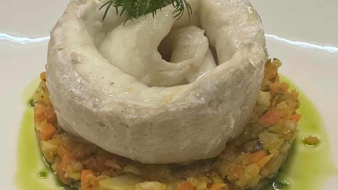 Orata al vapore con ragù di gamberi e verdure servita su insalata verde